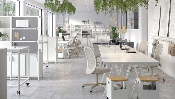 A bright and airy office space with white TROTTEN desks combined to form collaboration areas.