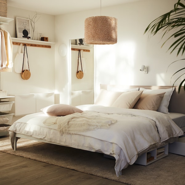 A bright bedroom with a KLEPPSTAD bed with white ÄNGSLILJA bed linen and a LERGRYN lamp hanging above it.