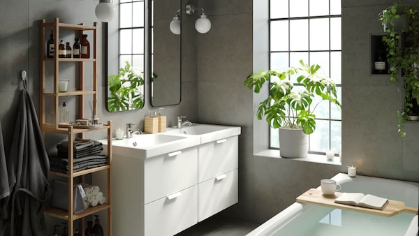 A white sink vanity cabinet with drawers and two sinks in a bathroom with a large window on the wall.