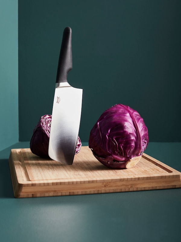 Chopping knife sticks to cutting board after cutting purple cabbage in half. 