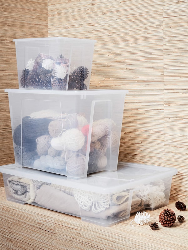 Clear plastic storage containers holding garments and fabric. 