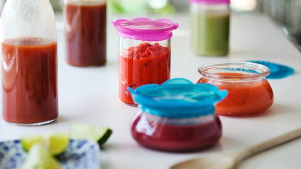 Fruit smoothies in glass containers with colorful plastic lids. 