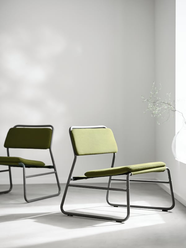 Two LINNEBÄCK easy chairs with black metal frames and Orrsta olive green covers facing in different directions in a room.