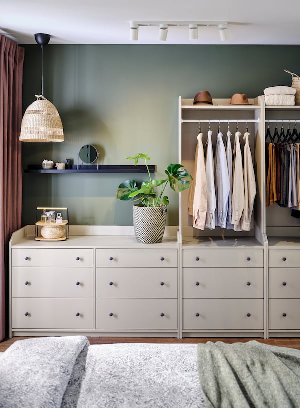 A serene bedroom with a white HAUGA chest of six drawers beside two HAUGA open wardrobes, each with three drawers.