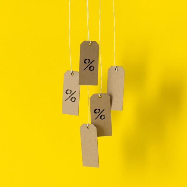 Price tags dangling on yellow background. 