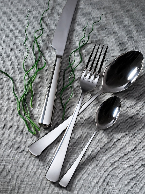 Silver flatware on gray tablecloth. 