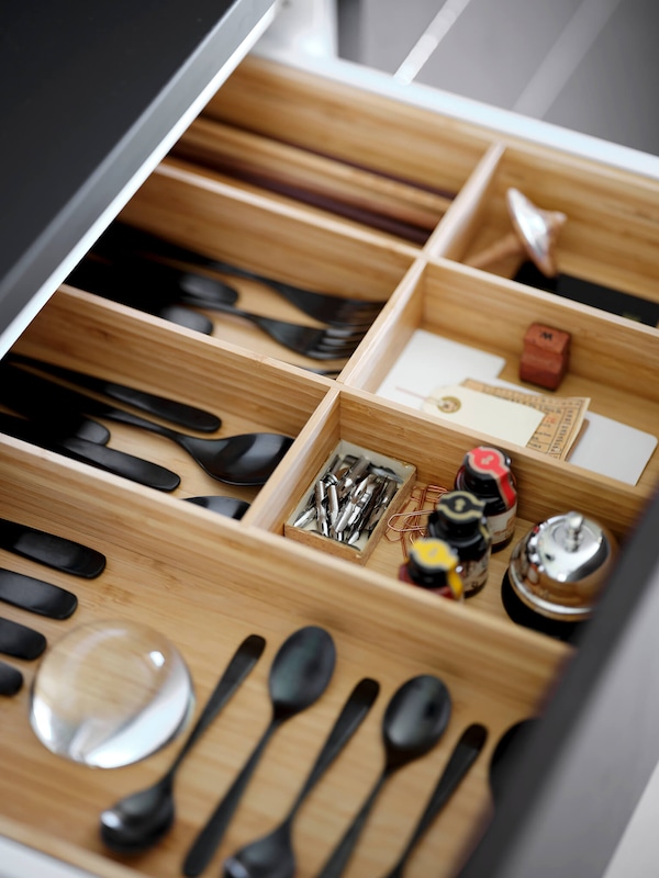 Wooden utensil drawer organizer with utensils. 